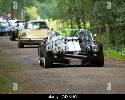 Oldtimer-Rallye in der belgischen Landschaft, AC Cobra 427 vor gefolgt von Porsche 911. Stockfoto