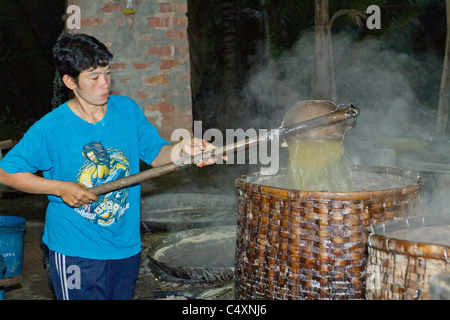 Herstellung von thai Palmzucker im Hause Fabrik, Amphawa schwimmenden Markt, Thailand. Gießt Sahne in Korb um es zu deaktivieren Stockfoto