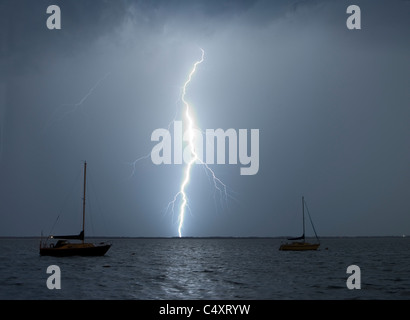 Ein Blitzschlag über Wasser in der Nähe ein paar Segelboote. Stockfoto