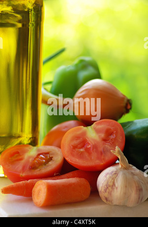 Olivenöl und Gemüse in grünem Hintergrund. Stockfoto