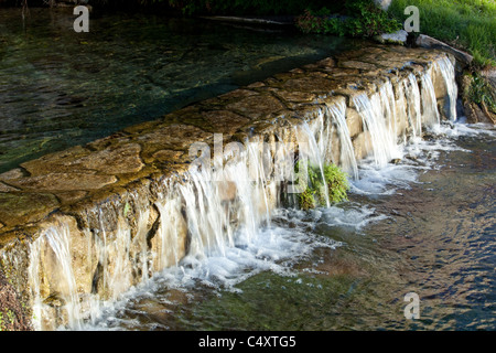 Klares Quellwasser fließt über niedrigen Wasserfall in Quellwasser gespeisten See an Unabhängigkeit Creek Naturschutzgebiet in West-Texas Stockfoto