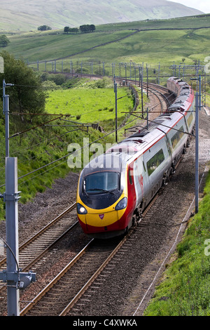 Stromleitungen, und Galgen für elektrische Züge British Railways Jungfrau pendolino am Bahnhof Shap. West Coast Line, Cumbria, Großbritannien Stockfoto