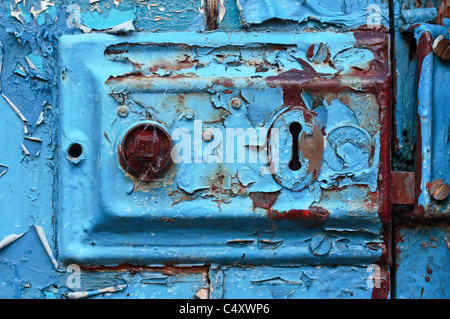 Schichten der abblätternde blaue Farbe auf einem alten Türschloss Stockfoto