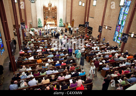 Die Mitglieder der Kirche gehen den Mittelgang entlang, um sich während des Ostersonntagsgottesdienstes in der lutherischen Kirche St. Martin für den Ritus der heiligen Kommunion zu verändern. ©Bob Daemmrich Stockfoto