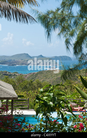 Frauen im Bikini sonnen am Pool im Bergresort auf Bequia, St. Vincent und den Grenadinen. Stockfoto