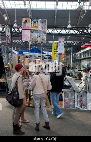 Junge Käufer vor eine Art Stall in Old Spitalfields Market in Bishopsgate, London, England, UK Stockfoto