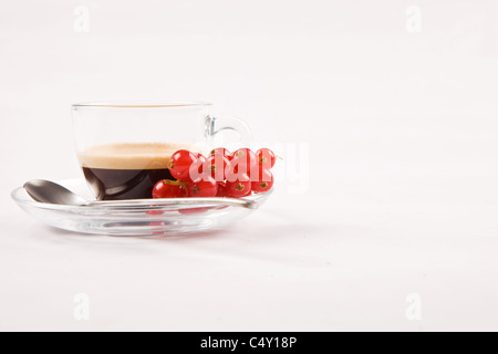 Foto von Espresso mit Johannisbeeren in Glasschale auf weißen Hintergrund isoliert Stockfoto