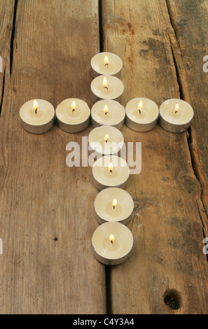 Kerzen bilden die Form eines Kreuzes auf rustikale Altholz Stockfoto