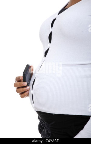 Schwangere Frau hält ein Handy gegen ihren Bauch. Isoliert auf weiss Stockfoto