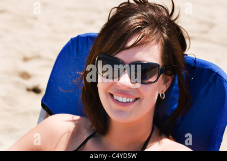 Eine schöne Brünette sitzt in einem Strandkorb auf dem Sand in Sayulita, Nayarit, Mexiko. Stockfoto