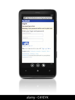 Windows 7 Phone. HTC HD7 Smartphone mit Facebook-Login-Seite auf dem Display isoliert auf weißem Hintergrund. Qualitativ hochwertige Fotos. Stockfoto