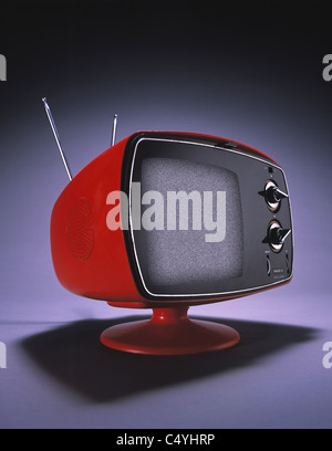 Ein kleine orangener Fernseher mit einer Antenne und große Zifferblätter. Stockfoto