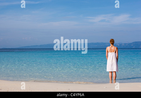 Eine Frau Paddel in das kristallklare Wasser von Vrika Beach. AntiPaxos, Griechenland. Stockfoto