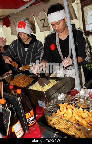 Zwei japanische Köche kochen einige Leckereien auf dem Moshi Moshi japanische Festival in Brighton, East Sussex, UK. Stockfoto