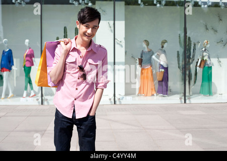 Junger Mann Holding Shopping Bags Stockfoto