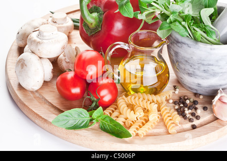 Olivenöl, Kräuter und Gemüse auf Schreibtisch. Stockfoto