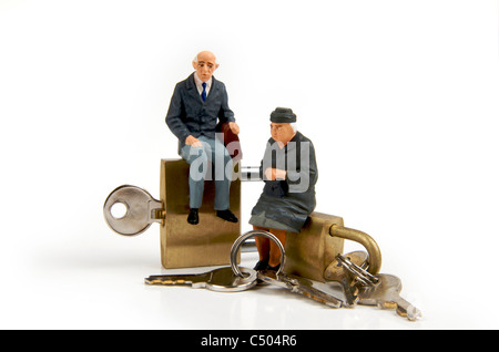 Miniatur-Figuren älteres Ehepaar sitzt auf Vorhängeschlösser Stockfoto