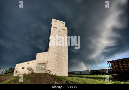 Prairie Getreidesilo in Saskatchewan Kanada mit dunklen Wolken und Regenbogen Stockfoto