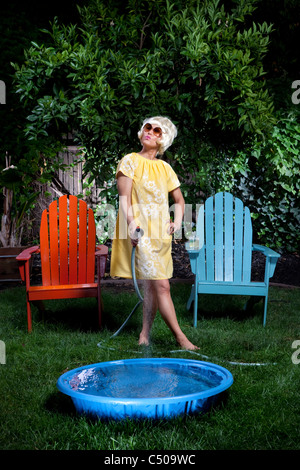 Koreanerin füllt sich kleinen Pool im Hinterhof Stockfoto