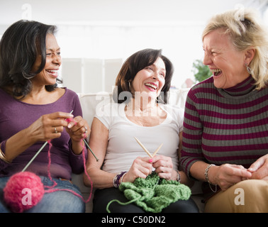 Freunde lachen und zusammen stricken Stockfoto