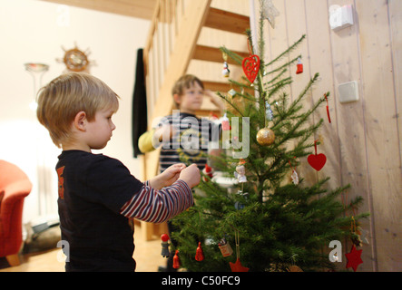 Kinder, die einen Weihnachtsbaum Dekoration Stockfoto