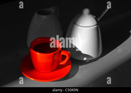 Rote Tasse Kaffee auf Graustufen-Hintergrund Stockfoto