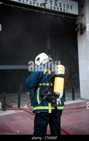 Feuerwehrleute versuchen, ein Feuer in einer Bank in Panepistimiou Straße während der Proteste in Athen Stockfoto