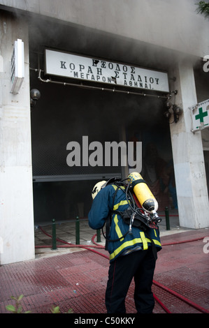 Feuerwehrleute versuchen, ein Feuer in einer Bank in Panepistimiou Straße während der Proteste in Athen Stockfoto