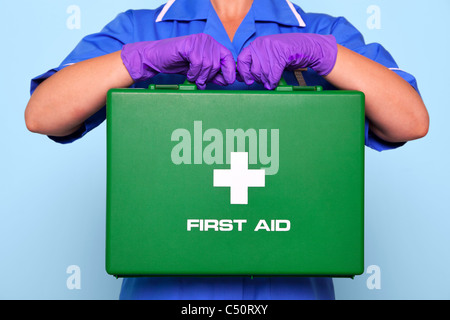 Foto von einer Krankenschwester in Uniform hält einen grünen Verbandskasten. Stockfoto