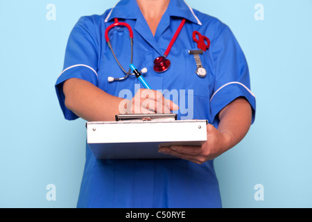 Foto von einer Krankenschwester in Uniform, die einen medizinischen Berichtsordner aktualisieren einige Patienten Hinweise halten. Stockfoto