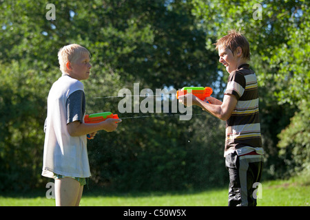 zwei Jungen spielen mit Wasserpistolen Stockfoto