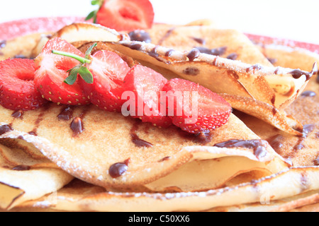 Pfannkuchen mit Erdbeeren auf rotem Teller Stockfoto