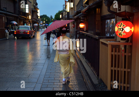 Eine japanische Geisha (Geiko) zu Fuß entlang traditionellen Restaurants im historischen Gion-Viertel, Kyoto, Japan JP Stockfoto