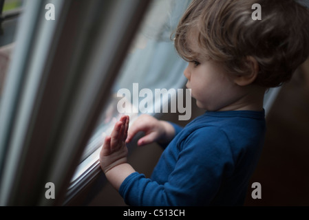 Kleinkind aus Fenster Stockfoto