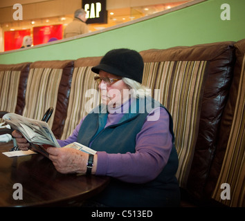 Ältere Dame lesen Zeitung Stockfoto