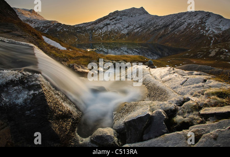 Ein kleiner Bach, der durch Skittendalen Tal in Troms Grafschaft, Norwegen. Rismålstinden Berg ist im Hintergrund. Stockfoto