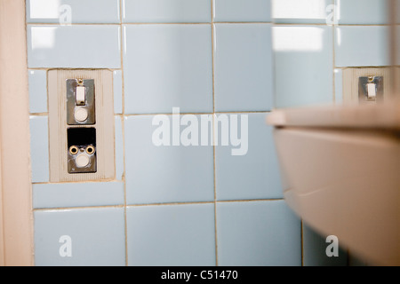 Ight-Schalter und Steckdose auf gefliesten Wand Stockfoto