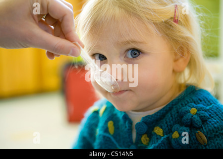 Babymädchen gefüttert Snack, beschnitten Stockfoto