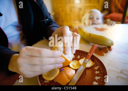 Mann peeling Orange für Babymädchen beschnitten Stockfoto