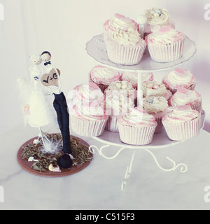 Hochzeit Cupcakes auf Kuchen stehen neben Braut und Bräutigam Kuchen topper Stockfoto