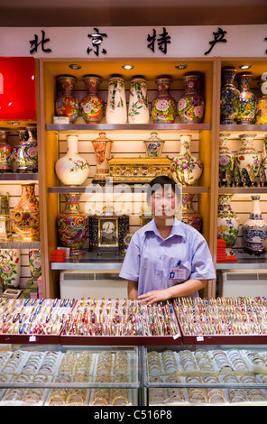 Erwachsene Frau / Frauen / Mädchen shop Assistentin mit Display & Zähler. Cloisonne Geschenkeladen im Sommer Palast Peking, China. Stockfoto