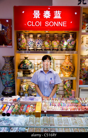 Erwachsene Frau / Frauen / Mädchen shop Assistentin mit Display & Zähler. Cloisonne Geschenkeladen im Sommer Palast Peking, China. Stockfoto