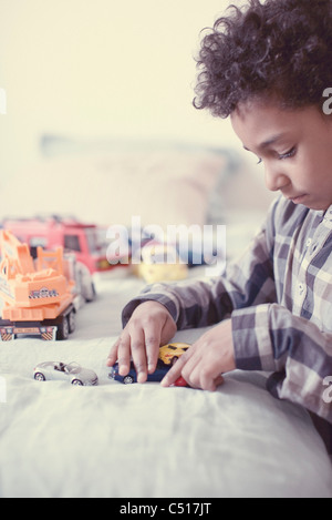 Kleiner Junge spielt mit Spielzeug-Autos Stockfoto