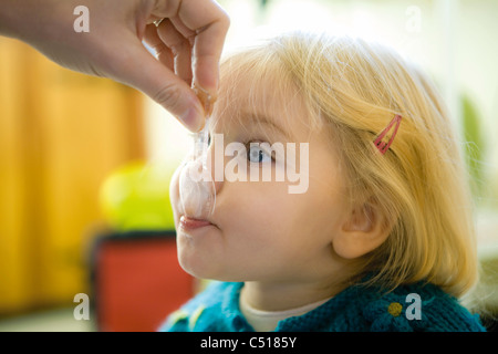 Babymädchen gefüttert Snack, beschnitten Stockfoto