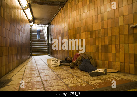 Obdachloser schlafen in u-Bahn Eingang/Ausgang, Rockefeller Center, New York City. Stockfoto