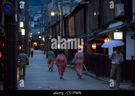 Zwei japanische Geisha (Geiko) zu Fuß entlang traditionellen Restaurants im historischen Gion-Viertel, Kyoto, Japan JP Stockfoto