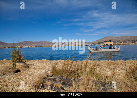 Blick aus einem der schwimmenden Inseln der Uros Touristen gerudert wird in einem traditionellen Reed Boot, Titicacasee, Peru Stockfoto