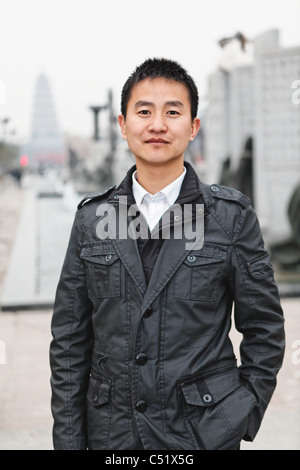 Porträt eines jungen chinesischen Mann stehend auf der Straße mit Hand in der Tasche, Xian, China Stockfoto