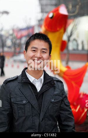 Porträt eines jungen chinesischen Mann lächelnd auf der Straße, Xian, China Stockfoto