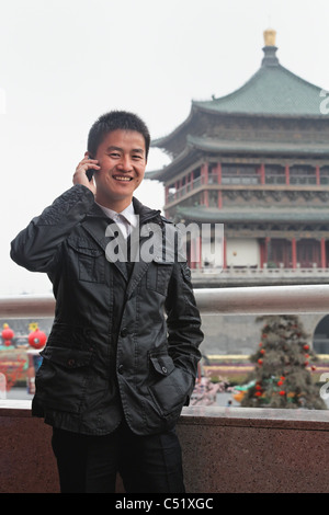 Junge chinesische Mann sprechen auf einem drahtlosen Telefon im Freien Stadt Xian, China Stockfoto